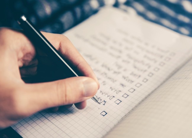 Hand writing checklist in notebook with pen